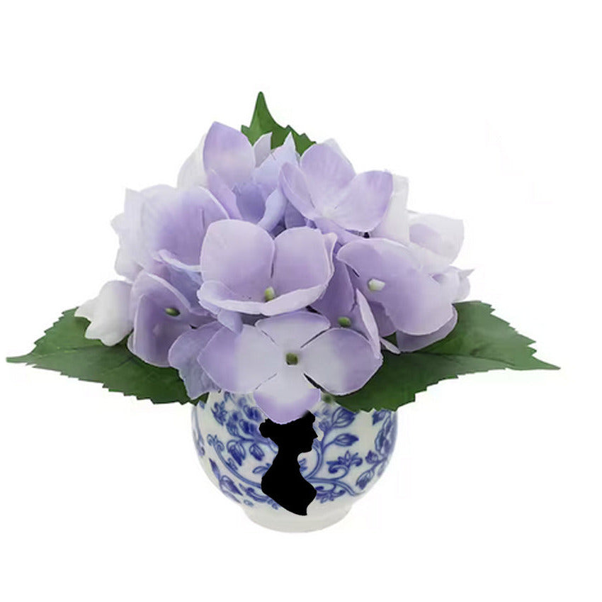 tiny teacup arrangment features purple hydrangea and jane Austen's silhouette.